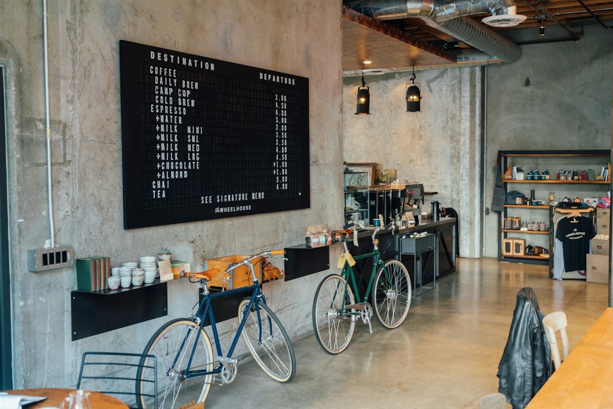 Two bicycles displayed in a bright bike shop and café