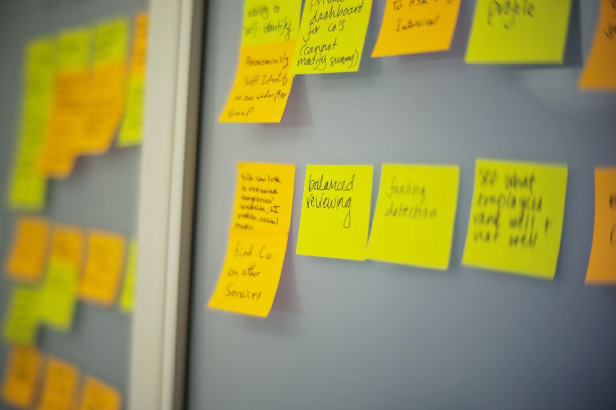 Yellow and orange sticky notes on a glass wall